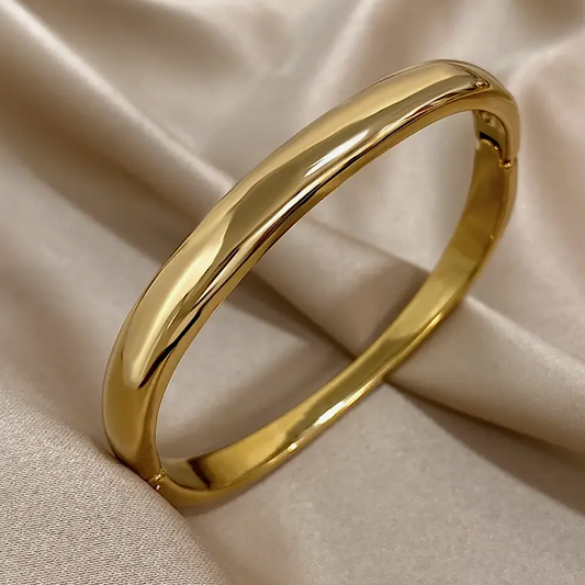 Gold bracelet on a beige fabric background