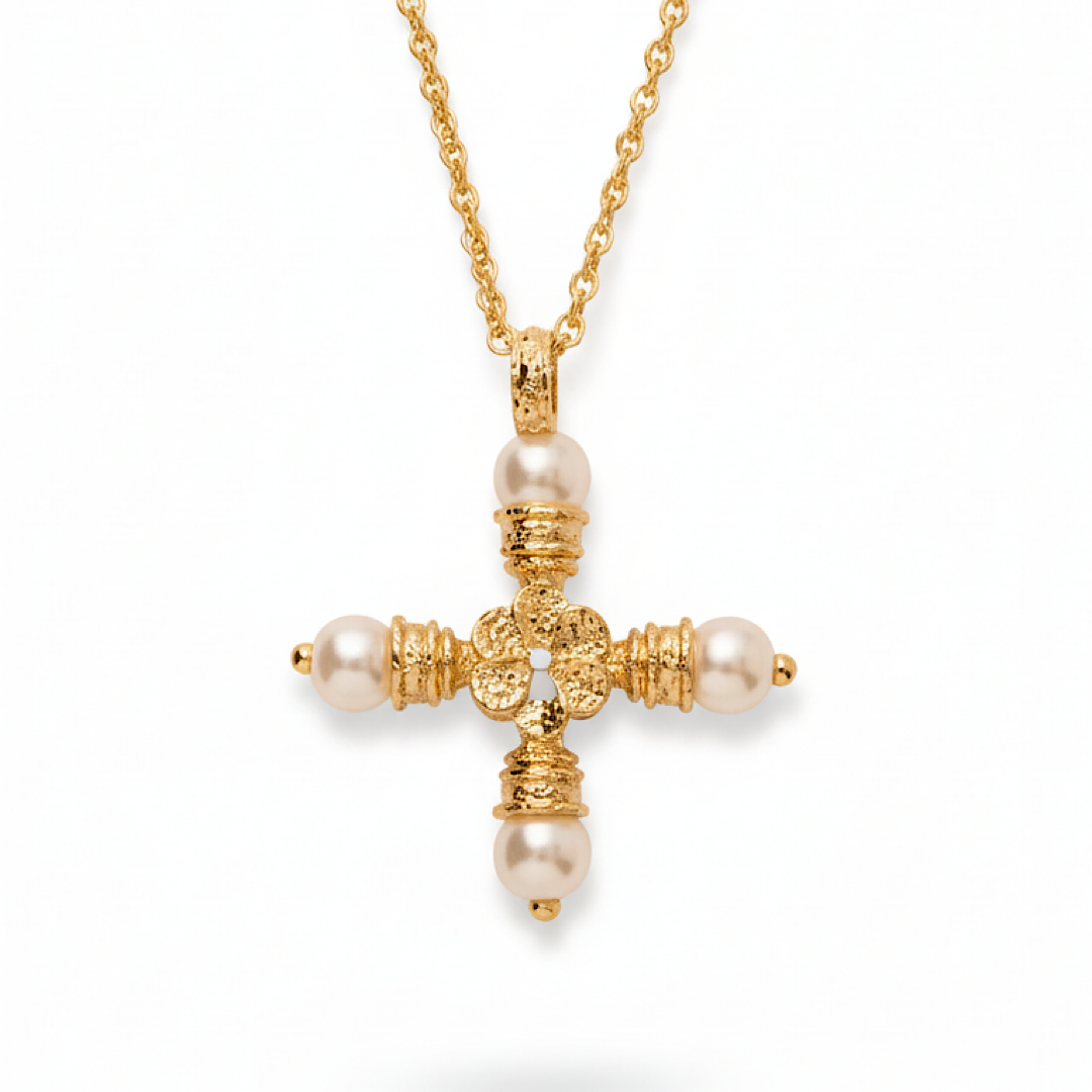 Gold cross necklace with pearl accents on a white background
