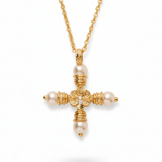 Gold cross necklace with pearl accents on a white background