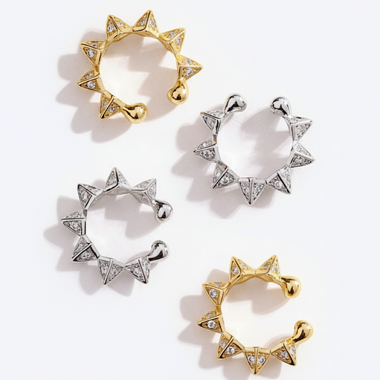 Set of gold and silver ear cuffs with star-like designs on a white background