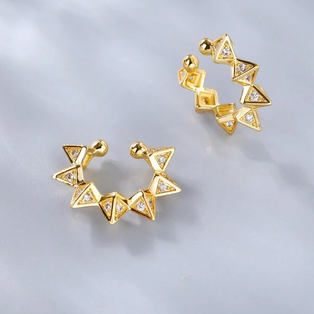 Gold geometric ear cuff on a light gray background