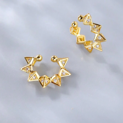 Gold geometric ear cuff on a light gray background