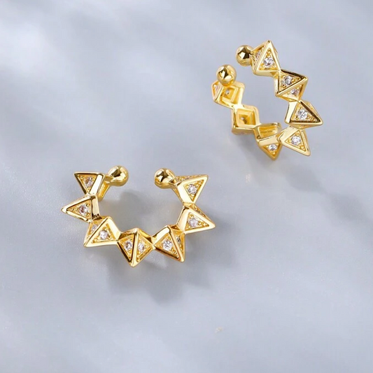 Gold geometric ear cuff on a light gray background