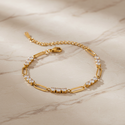 Gold bracelet with diamond accents on a marble surface